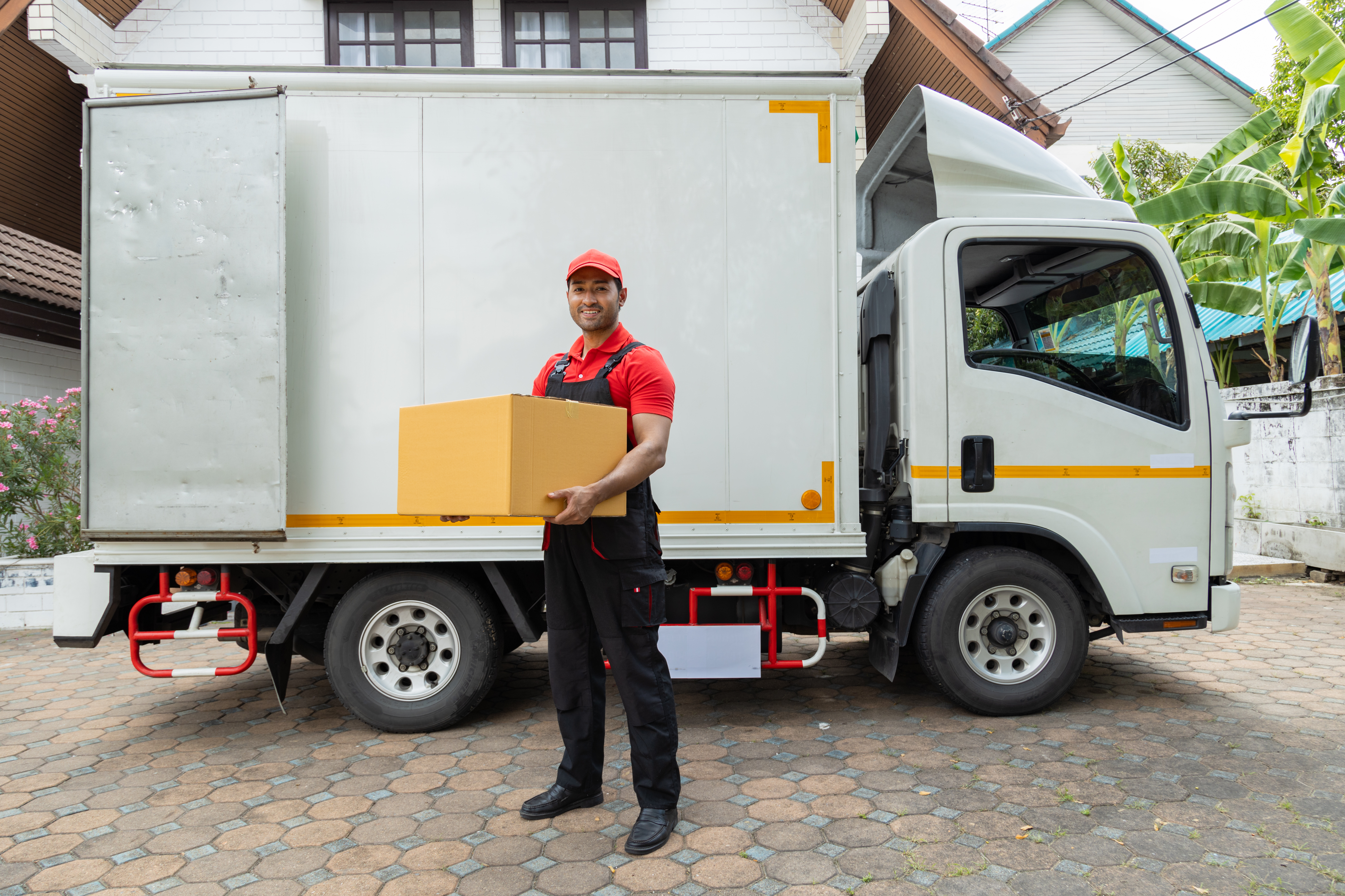 Portrait of two movers unloading boxes and furniture from a pickup truck.